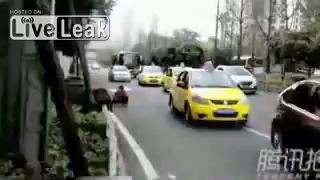 Woman pisses towards oncoming traffic on road