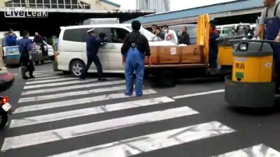 Японский полицейский с дубинкой против хулигана с ножом. Рыбный рынок Цукидз ...